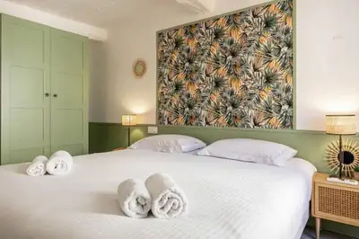 a bedroom with a large white bed with towels on it at Hé Jude le Suquet in Cannes