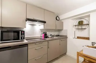 a kitchen with white cabinets and a microwave at Hé Jude le Suquet in Cannes