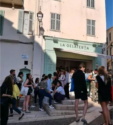 a crowd of people standing outside of a store at Hé Jude le Suquet in Cannes
