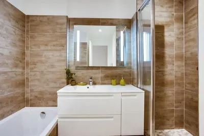 a bathroom with a white sink and a shower at Appartement Alexandre lumineux avec superbe vue mer in Cannes