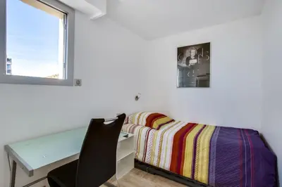 a bedroom with a desk and a bed and a window at Appartement Alexandre lumineux avec superbe vue mer in Cannes