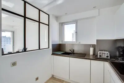 a kitchen with white cabinets and a window at Appartement Alexandre lumineux avec superbe vue mer in Cannes
