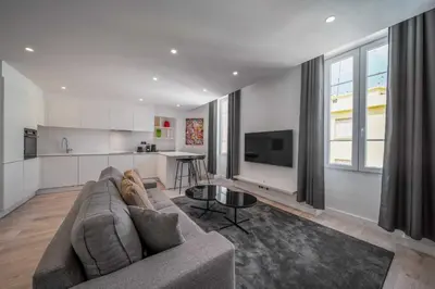 a living room with a couch and a kitchen at Charming apartment for 4 people - Forville Market in Cannes