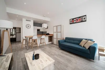 a living room with a blue couch and a table at Appartement de charme proche Vieux Port et Palais in Cannes