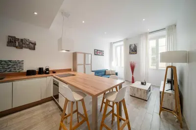 a kitchen with a table and chairs in a room at Appartement de charme proche Vieux Port et Palais in Cannes