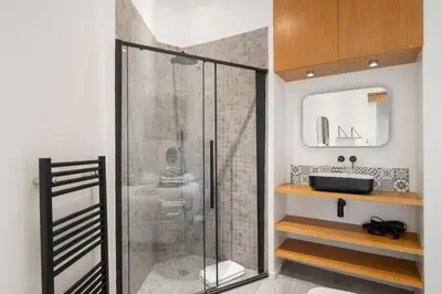 a bathroom with a glass shower with a sink at Appartement de charme proche Vieux Port et Palais in Cannes