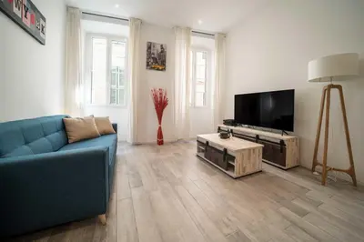 a living room with a blue couch and a flat screen tv at Appartement de charme proche Vieux Port et Palais in Cannes