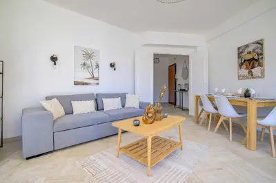 a living room with a blue couch and a table at Sublime Two bedroom apartment with Terrace in Cannes