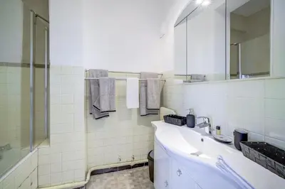 a white bathroom with a sink and a mirror at Sublime Two bedroom apartment with Terrace in Cannes
