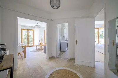 a living room with white walls and wooden floors at Sublime Two bedroom apartment with Terrace in Cannes