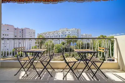 two tables and chairs on a balcony with a view of buildings at Sublime Two bedroom apartment with Terrace in Cannes