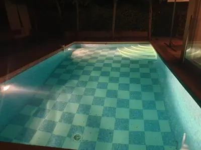 an empty swimming pool with a checkerboard floor at Superb Villa, heated swimming pool, central location, secluded gardens in Cannes