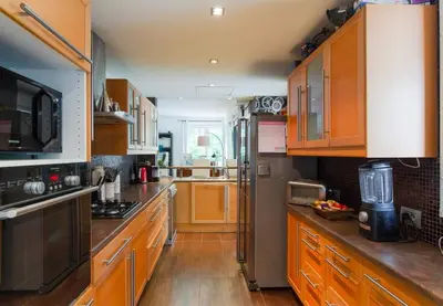 a large kitchen with wooden cabinets and a large counter top at Superb Villa, heated swimming pool, central location, secluded gardens in Cannes