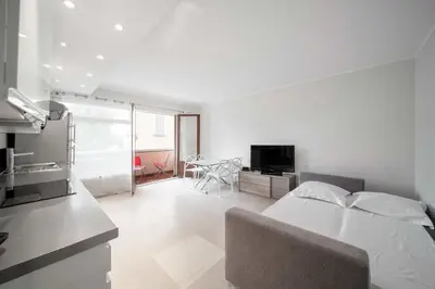a bedroom with a bed and a kitchen with a table at Magnifique appartement T3 centre Cannes in Cannes