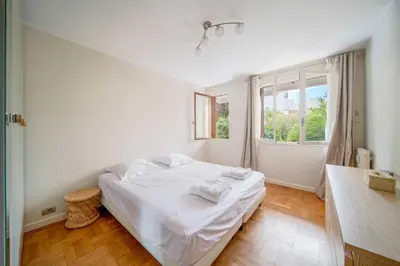 a white bedroom with a bed and a window at Magnifique appartement T3 centre Cannes in Cannes