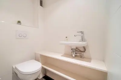 a white bathroom with a toilet and a sink at Magnifique appartement T3 centre Cannes in Cannes