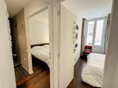 a small room with two beds and a mirror at GAB1 - 3 pièces au cœur du centre ville in Cannes