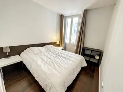 a bedroom with a bed and two tables and a window at GAB1 - 3 pièces au cœur du centre ville in Cannes
