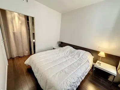 a bedroom with a bed with a white comforter at GAB1 - 3 pièces au cœur du centre ville in Cannes