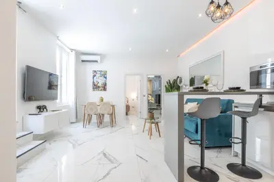 a white living room with a table and chairs at LB Vacation Rentals I Renovated Apt Minutes from Beach - Palais - 30m2 Terrace in Cannes
