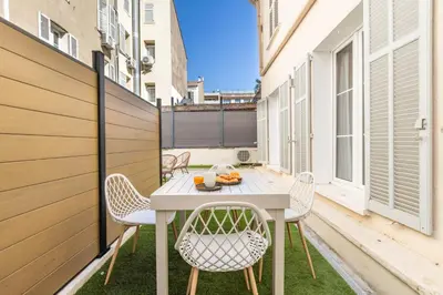 a patio with a table and chairs on a balcony at LB Vacation Rentals I Renovated Apt Minutes from Beach - Palais - 30m2 Terrace in Cannes