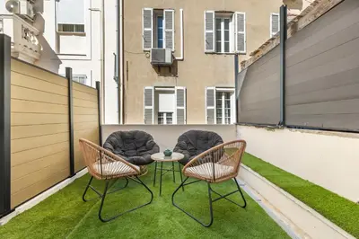 two chairs and a table on a balcony with grass at LB Vacation Rentals I Renovated Apt Minutes from Beach - Palais - 30m2 Terrace in Cannes