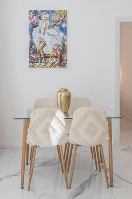 a glass table with two chairs and a painting on the wall at LB Vacation Rentals I Renovated Apt Minutes from Beach - Palais - 30m2 Terrace in Cannes