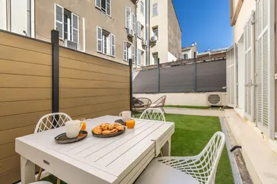 a table with a bowl of food on a balcony at LB Vacation Rentals I Renovated Apt Minutes from Beach - Palais - 30m2 Terrace in Cannes