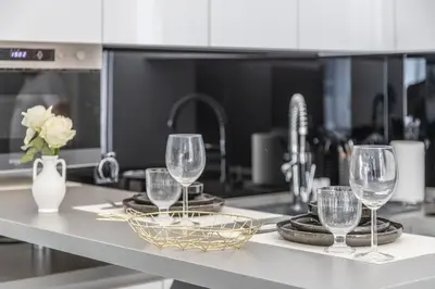 a kitchen counter with three wine glasses on it at LB Vacation Rentals I Renovated Apt Minutes from Beach - Palais - 30m2 Terrace in Cannes