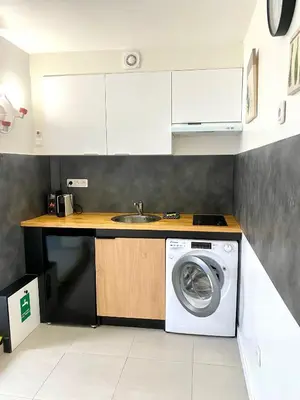 a kitchen with a washing machine and a sink at Grand Studio centre de Cannes in Cannes