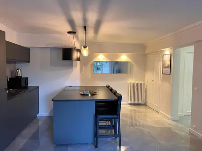 a kitchen with a island in the middle of a room at Les Arènes - Cannes centre, Charmant 2 pièces récemment rénové de 45 m2 avec sa terrasse de 10 m2 in Cannes