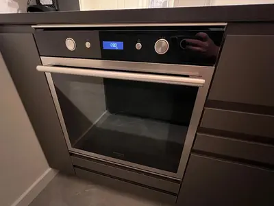 a black oven with an open door in a kitchen at Les Arènes - Cannes centre, Charmant 2 pièces récemment rénové de 45 m2 avec sa terrasse de 10 m2 in Cannes