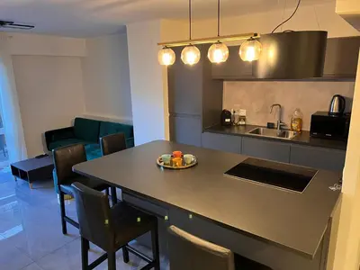 a kitchen with a table with a plate of fruit on it at Les Arènes - Cannes centre, Charmant 2 pièces récemment rénové de 45 m2 avec sa terrasse de 10 m2 in Cannes