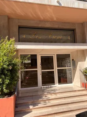 a store front with glass doors and a sign on it at Les Arènes - Cannes centre, Charmant 2 pièces récemment rénové de 45 m2 avec sa terrasse de 10 m2 in Cannes
