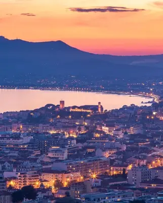 a view of a city at night with a body of water at Les Arènes - Cannes centre, Charmant 2 pièces récemment rénové de 45 m2 avec sa terrasse de 10 m2 in Cannes