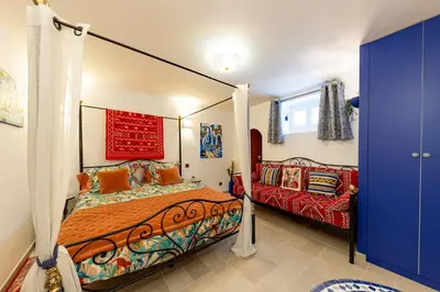 a bedroom with a canopy bed and a couch at Les Jardins de Marrakech Super centre in Cannes