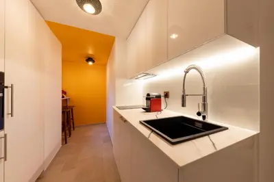 a kitchen with white cabinets and a sink at Les Jardins de Marrakech Super centre in Cannes