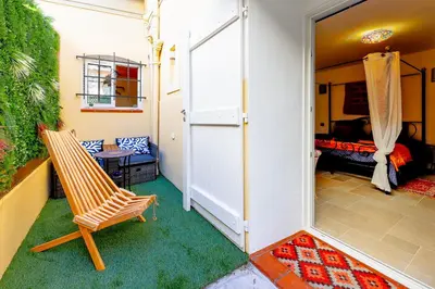 a room with a chair and a bedroom at Les Jardins de Marrakech Super centre in Cannes