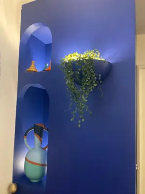 a blue wall with a vase and a plant at Les Jardins de Marrakech Super centre in Cannes