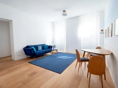 a living room with a blue couch and a table at Appartements proche Croisette, Casino, plages, centre ville et Gare in Cannes