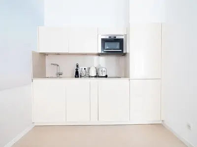 a kitchen with white cabinets and a microwave at Appartements proche Croisette, Casino, plages, centre ville et Gare in Cannes