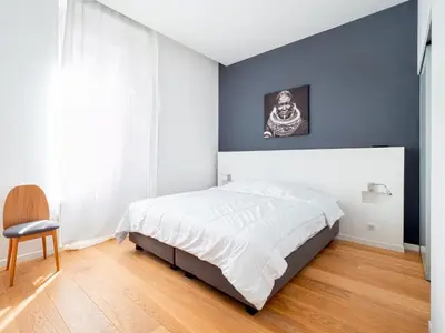 a bedroom with a white bed and a blue wall at Appartements proche Croisette, Casino, plages, centre ville et Gare in Cannes