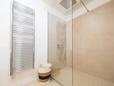 a glass shower with a trash can in a bathroom at Appartements proche Croisette, Casino, plages, centre ville et Gare in Cannes