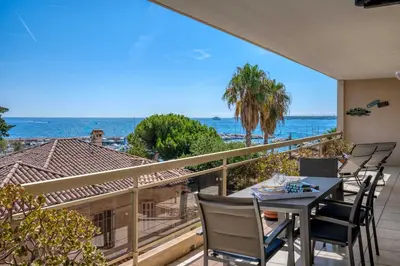 a balcony with a table and chairs and the ocean at Bright apartment with sea view - Palm Beach in Cannes