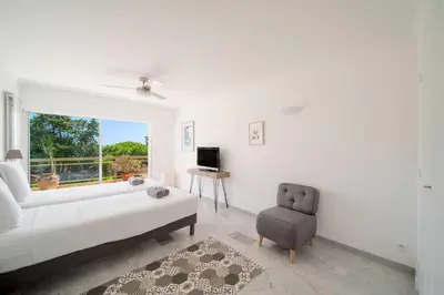 a white living room with a couch and a chair at Bright apartment with sea view - Palm Beach in Cannes