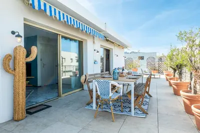 a patio with a table and chairs and a cactus at 2-Br Rooftop in Palm Beach 2-min walk to beaches in Cannes