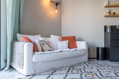 a white couch with pillows on it in a living room at 2-Br Rooftop in Palm Beach 2-min walk to beaches in Cannes