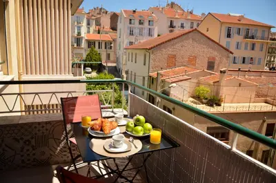 a table with a bowl of fruit on a balcony at AzurAppart 3-rooms Cannes Carnot in Cannes