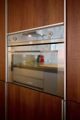a glass oven in a kitchen with a wooden wall at AzurAppart 3-rooms Cannes Carnot in Cannes