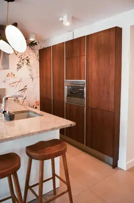 a kitchen with wooden cabinets and a counter with stools at AzurAppart 3-rooms Cannes Carnot in Cannes